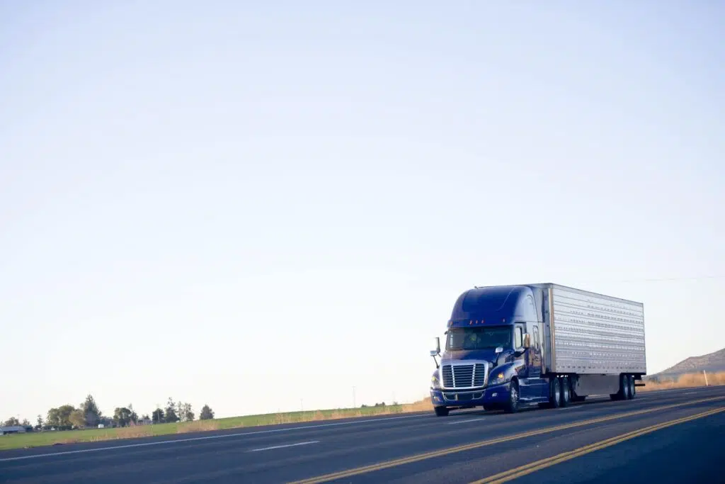 Blue modern semi truck reefer trailer carry cargo on highway
